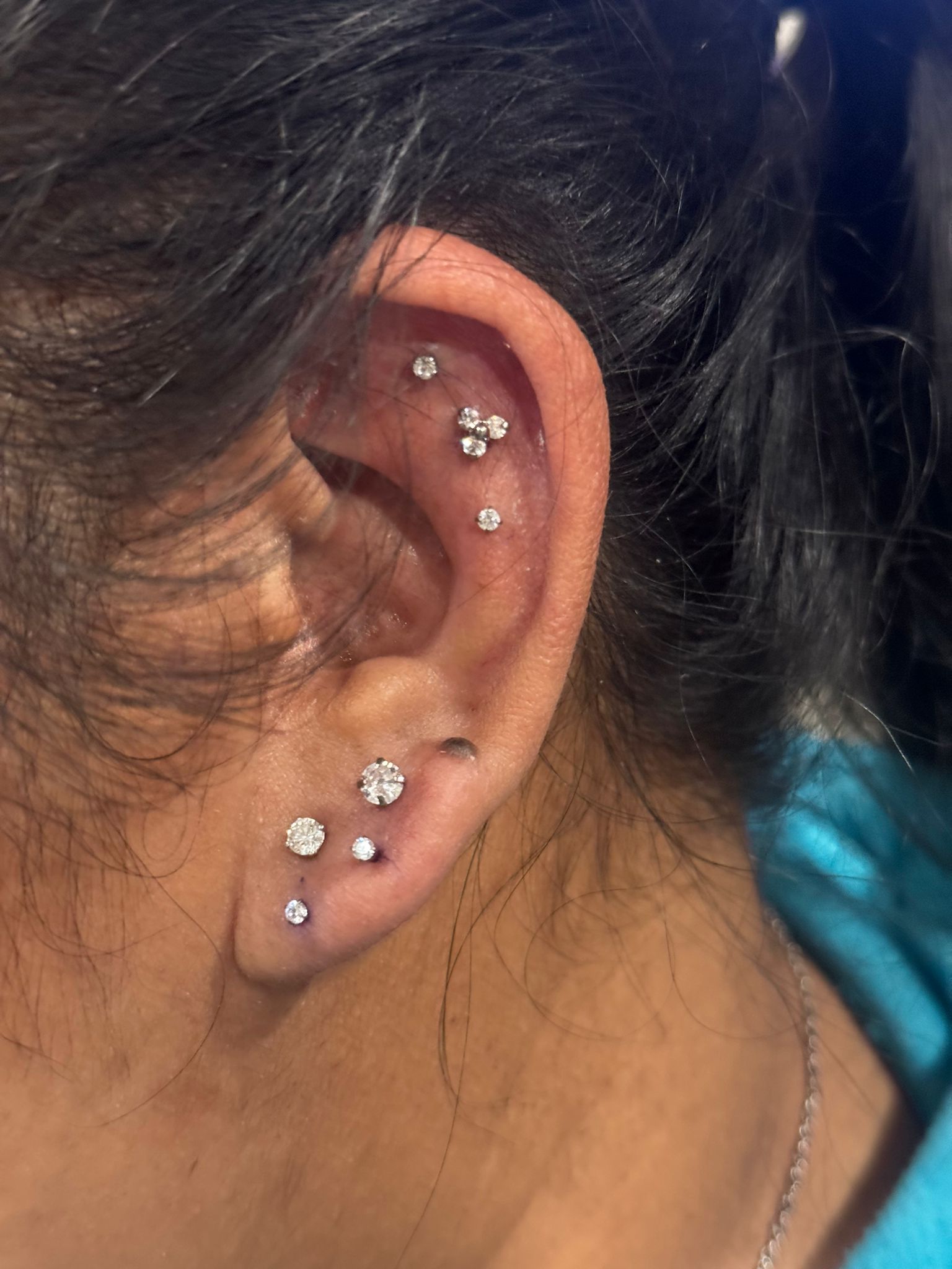 Curated ear with multiple piercings including helix and lobe